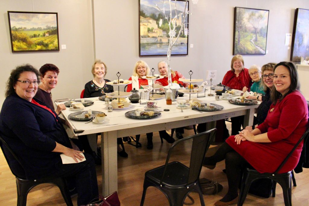 Women enjoy a tea sitting at a table for Christmas